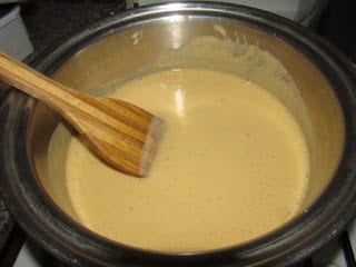 Stirring blended plantain in a pot
